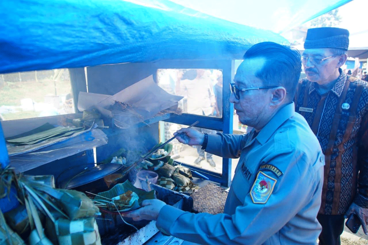 Bupati Tanah Datar, Eka Putra mengambil sate yang disantap. (Prokopim)