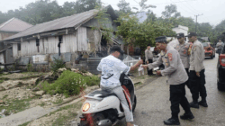 Kapolsek Sangia Wambulu Ipda Suharno, membagikan takjil kepada pengendara yang melintas di jalan raya.