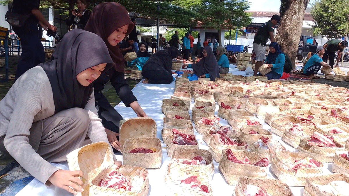 Panitia kurban Unmuh Jember menyiapkan daging dalam wadah besek bambu yang akan dibagikan kepada penerima di lingkungan sekitar kampus, Rabu (27/5/2026). (Mahrus Sholih)